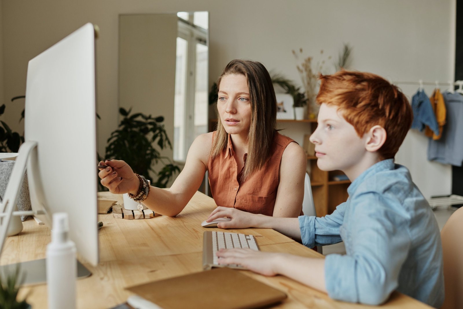 teacher instructing a kid by pointing at a monitor